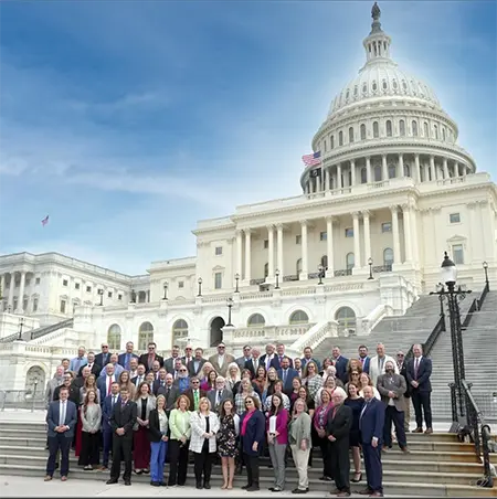 Large group of representatives of the Northwest Ohio Counties Farm Bureaus stand on the steps outside of a government building in Washington D.C. during their March 2026 President's trip to the capital to meet with government officials to discuss issues concerning farmers.